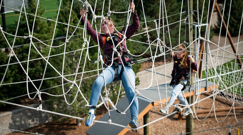 Two girls climbing the ropes