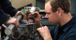 An automotive student works on an engine
