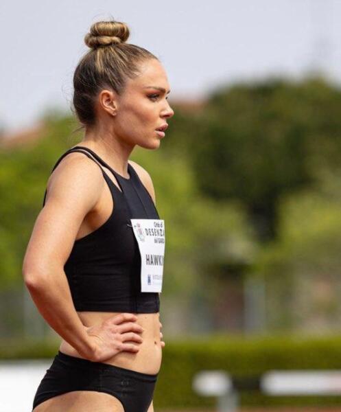 Chari Hawkins stands in profile with her hands on her hips