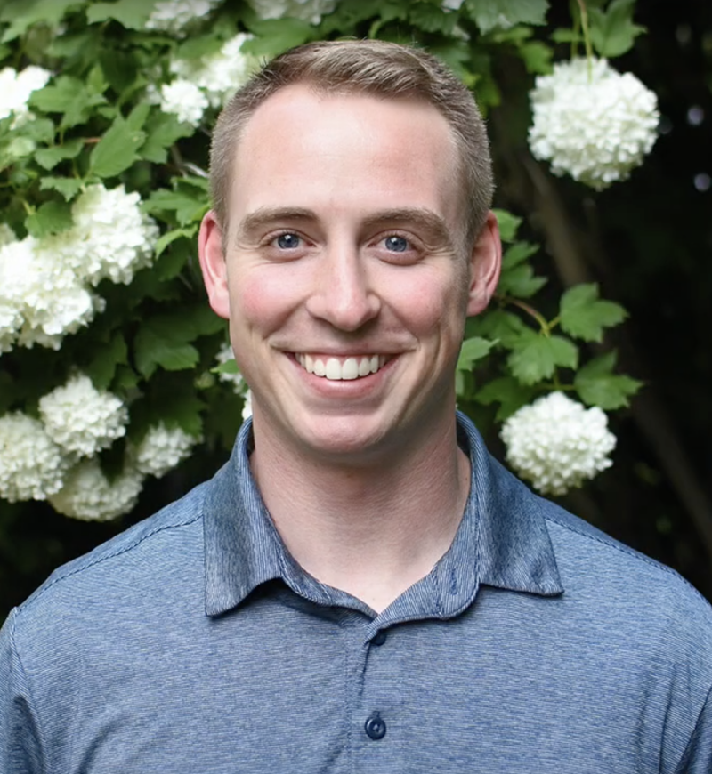 Photo of Devin Bean in front of a hydrangea bush