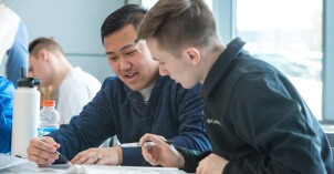 Two male students help teach each other in a Human Nutrition lab.