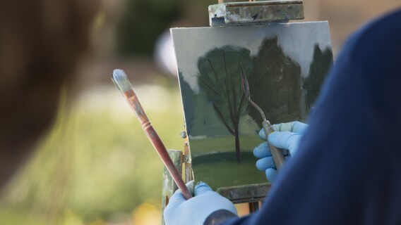Brother Bodily gives a painting demonstration during his Oil Painting class outside the Spori Building.