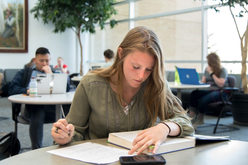 Students sitting at a table studying on campus.