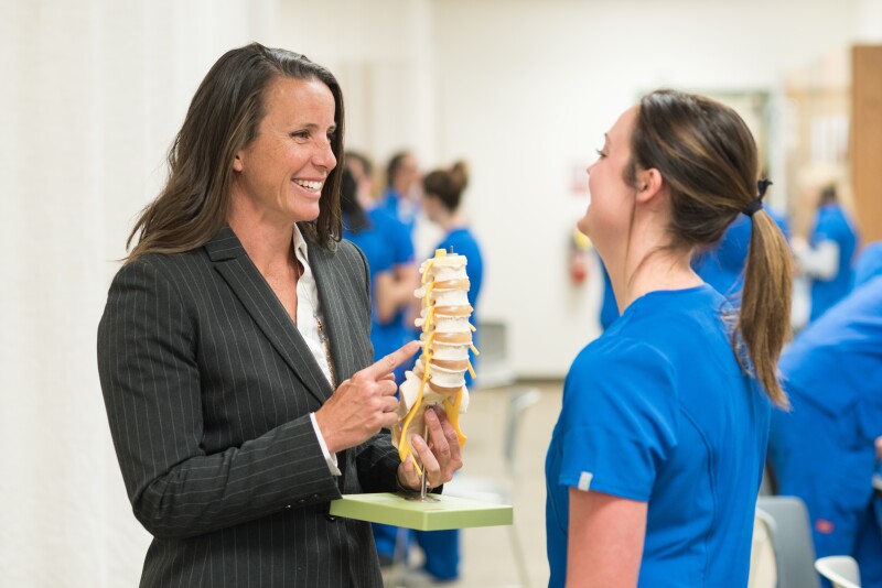 Erin Bennion helps students in a nursing lab. 2017