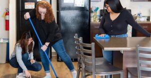 Girls cleaning their apartment kitchen