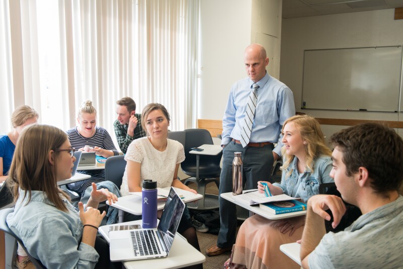 Students during a class at BYU-Idaho with their desks circled together in different groups having discussions.