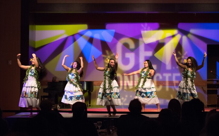Five women dance in a luau in the Manwaring Ballroom