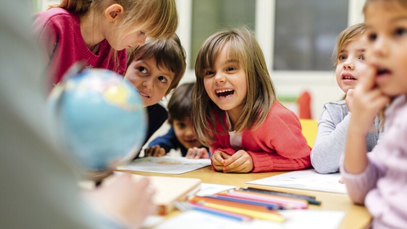 Little students laugh and play together in school.