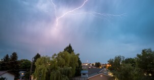 A flash of lightning strikes across the sky above a residential neighborhood in Rexburg, Idaho.