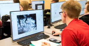 A geology student works on a desktop computer