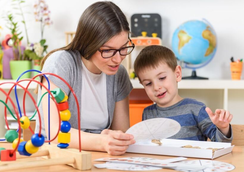 Teacher plays with a young boy.