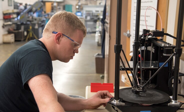 A student views the 3D Printing machine.