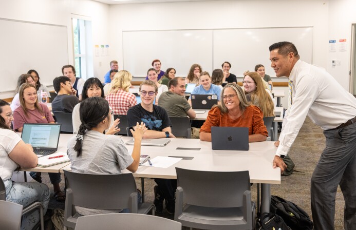 An early education student talks with her professor and classmates