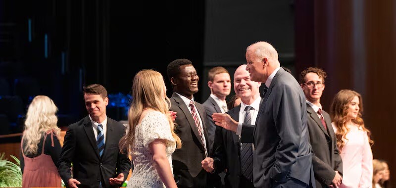 Elder David P. Homer, a General Authority Seventy, greets BYU–Idaho students May 20, 2025, at campus devotional in Rexburg, Idaho.