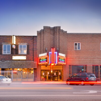 A front view of the Romance Theatre near sunset.