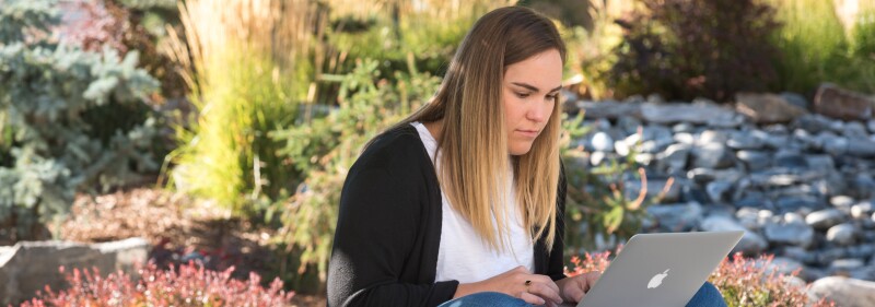 A student works on her laptop outside