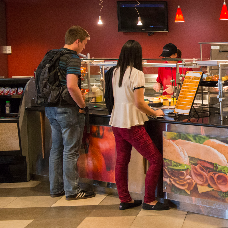 Two BYU-Idaho students wait patiently for their food orders in the food court at the Manwaring Center. There are many eateries that give variety to student life on campus.