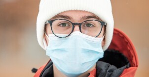 A student wears a protective face mask while posing for a photograph on the BYu-Idaho campus.
