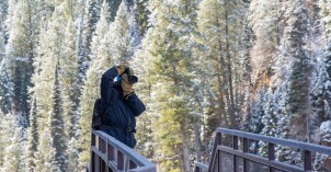A student takes photos of Mesa Falls in the winter.
