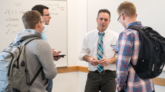 Math Education students talk with a professor.