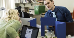 Two students build 3d models in one of their graphic design classes.