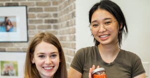 Two female BYU-Idaho students display canned jam during a Relief Society activity on the BYU-Idaho campus.