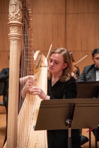 Student performing the harp in the Chamber Orchestra