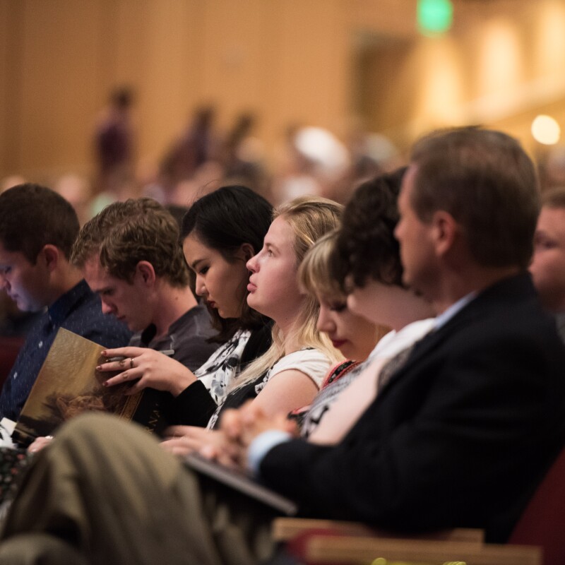 Several BYU-Idaho students listen intently during a devotional at the BYU-Idaho Center.