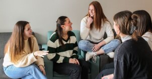 Roommates talking together in their apartment living room.