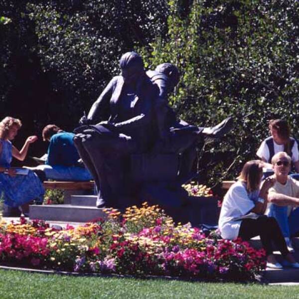 A group of students sitting by a statue on the BYU-Idaho campus.