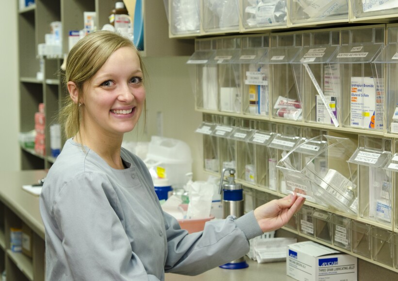 Student Employee, smiling at the camera, working at the Health Center.