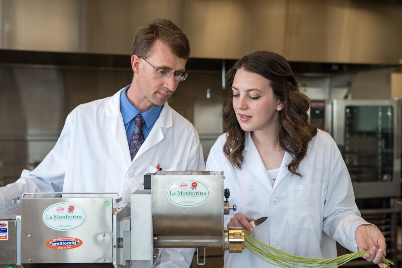 Food Science Instructor Neal Ricks and student, Katelynn Palmer, working with the noodle press.