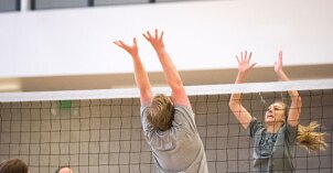 Students play volleyball on campus.