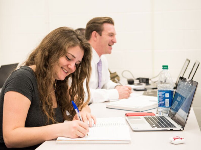 Business Management students take notes and complete work.