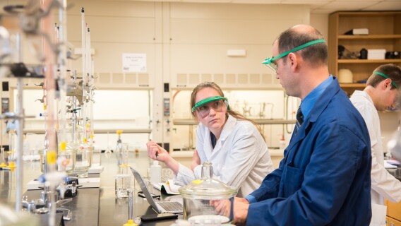Student consults a professor while in their chemistry lab
