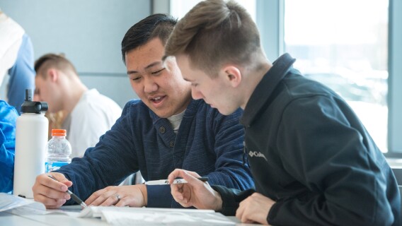 Two male students help teach each other in a Human Nutrition lab.