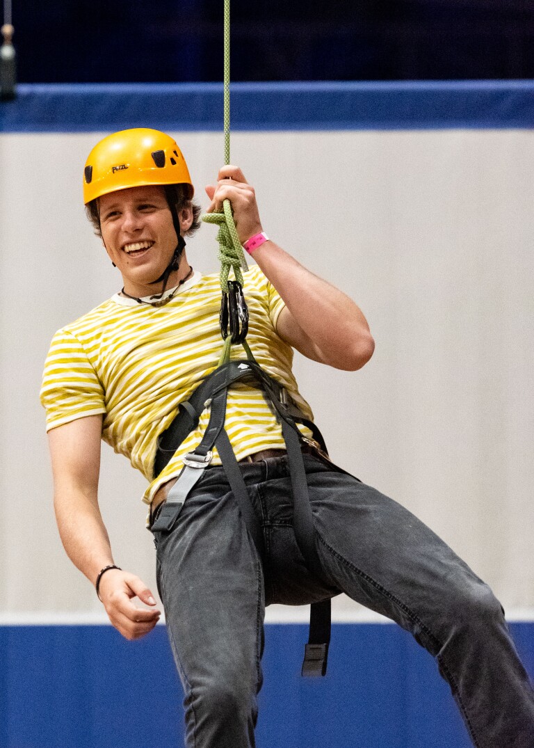 Student hanging from a harness in the I-Center on First Friday