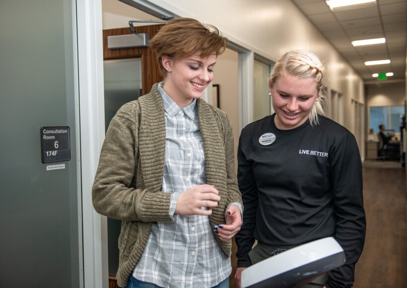 A female student smiles while taking an InBody Test in the BYu-Idaho Wellness Center.