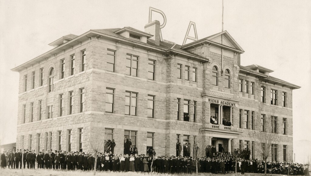 A vintage photograph of graduates in front of the original Spori Building, also called the Ricks Academy Building.