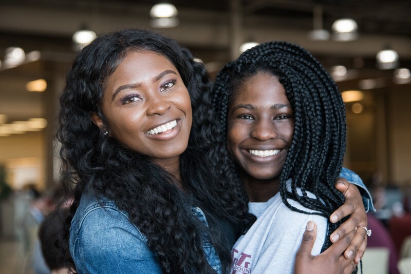 Two BYU-Idaho students hugging and smiling at the camera.