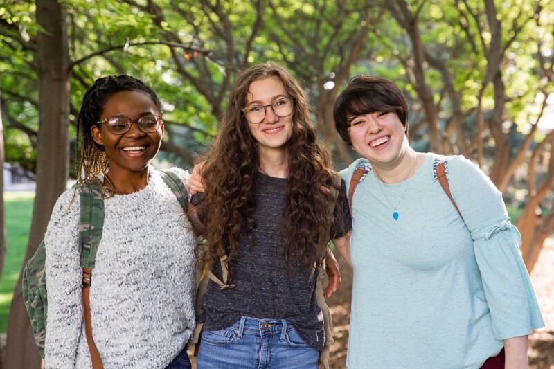 Three BYU-Idaho students standing and smiling at the camera.