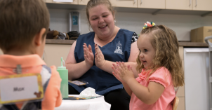 Daycare children excitedly engaged in an activity led by a daycare student