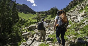 A professor and students go hiking on a massive rocky mountainside.
