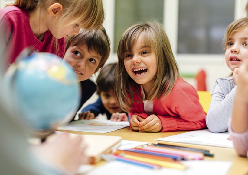 Little students laugh and play together in school.