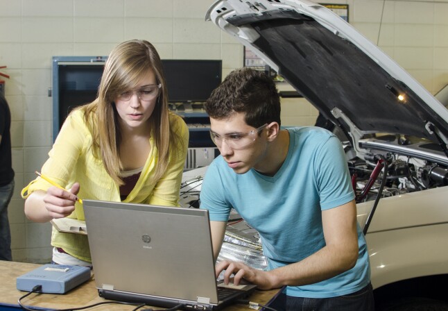 Students look at a computer in the Automotive Lab.