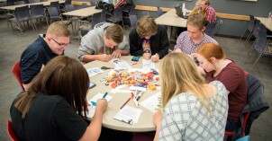 A BYU-Idaho Family Home Evening group completes a service project filling candy bags with encouraging messages.