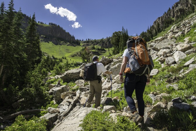 A professor and students go hiking on a massive rocky mountainside.