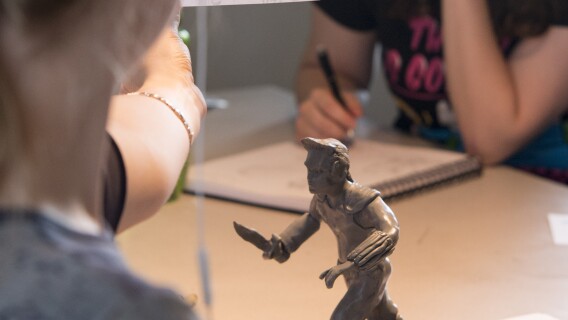Students work on their projects for class. The project in the image is a 3d figurine.