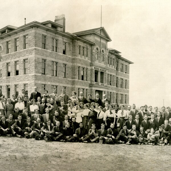 Vintage photo of the Spori Building from 1910 with a large group of people in front.