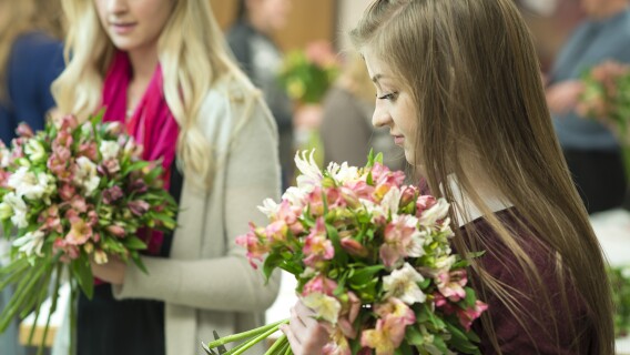 Two female students practice making bouquets in Ben Romney's Floral Design class